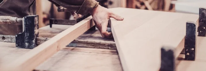 Person baut Holzrahmen mit Schraubzwingen